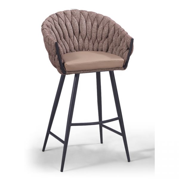 A high bar stool with a woven, textured brown backrest and a cushioned beige seat. The stool features black, splayed metal legs and a circular footrest. The design combines comfort and modern style.