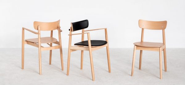 Three Nopp Chairs are arranged on a light-colored floor against a white background. The chair on the left features armrests and a curved backrest, the middle chair has a black cushion on the seat and backrest, and the right chair showcases a simple, armless design.