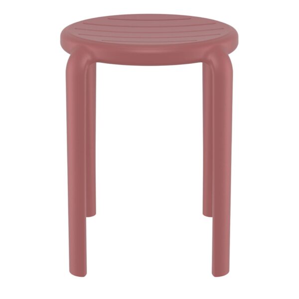 The Tom Stool is a small, round, four-legged piece featuring a smooth, solid surface with a reddish-pink finish. Its cylindrical legs are slightly curved at their junction with the seat, which boasts a subtly textured design. The stool embodies a modern, minimalist aesthetic.