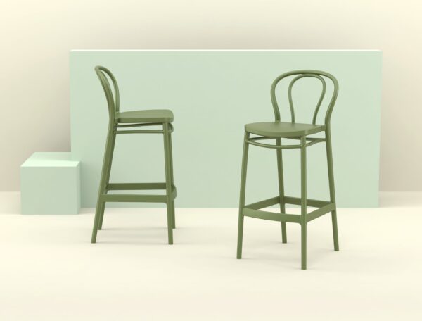 A minimalistic image showcasing two Victor Barstools with curved backrests and footrests, set against a pastel green background. One stool is facing the camera directly, while the other is slightly angled to the left. A light green rectangular block and a cube are in the background.