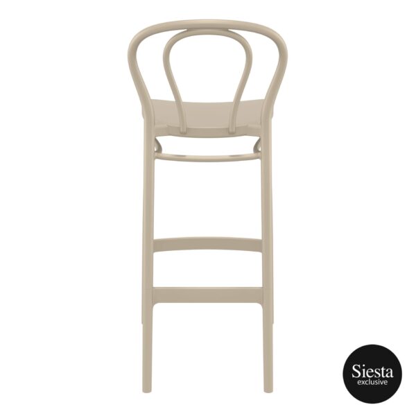 The Victor Barstool is a beige wooden stool featuring a curved backrest and two horizontal supports beneath the seat. With a minimalist design, clean lines, and sturdy structure, it embodies simplicity and elegance. The "Siesta exclusive" logo is located in the bottom right corner.